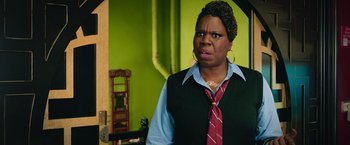 Movie still from “Ghostbusters” (2016), directed by Paul Feig – A woman wearing a red tie standing in front of a green wall; Close Up shot, Over the shoulder angle
