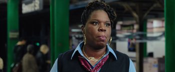 Movie still from “Ghostbusters” (2016), directed by Paul Feig – A woman in a black vest and a blue shirt; Close Up shot, Over the shoulder angle