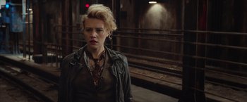 Movie still from “Ghostbusters” (2016), directed by Paul Feig – A woman in a leather jacket standing on a train platform; Close Up shot, Over the shoulder angle