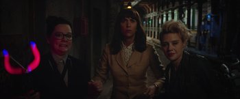 Movie still from “Ghostbusters” (2016), directed by Paul Feig – A group of people standing in a dark alley; Medium shot, High angle
