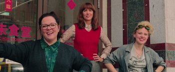 Movie still from “Ghostbusters” (2016), directed by Paul Feig – A woman standing next to two other women; Medium shot, Low angle