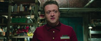 Movie still from “Ghostbusters” (2016), directed by Paul Feig – A man in a red shirt is looking at the camera; Close Up shot, Low angle