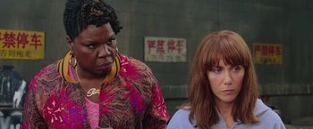 Movie still from “Ghostbusters” (2016), directed by Paul Feig – Two women standing next to each other in front of a building; Close Up shot, Over the shoulder angle