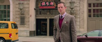 Movie still from “Ghostbusters” (2016), directed by Paul Feig – A man standing in front of a building; Medium shot, Low angle