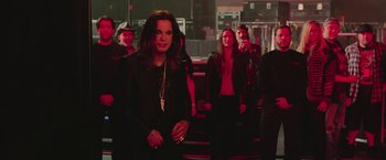 Movie still from “Ghostbusters” (2016), directed by Paul Feig – A group of people standing in front of a stage; Medium shot, Over the shoulder angle