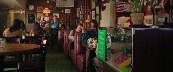 Movie still from “Ghostbusters” (2016), directed by Paul Feig – A man sitting at a booth in a restaurant; Wide shot, Over the shoulder angle