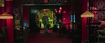 Movie still from “Ghostbusters” (2016), directed by Paul Feig – A man in a suit and hat standing in a room; Wide shot, Low angle