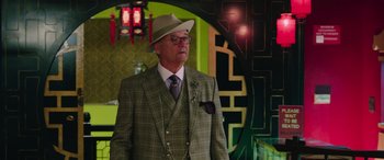 Movie still from “Ghostbusters” (2016), directed by Paul Feig – An older man wearing a suit and a hat; Medium shot, Low angle