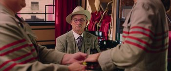 Movie still from “Ghostbusters” (2016), directed by Paul Feig – An older man wearing a hat and glasses; Close Up shot, Over the shoulder angle