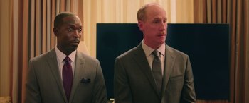 Movie still from “Ghostbusters” (2016), directed by Paul Feig – Two men in suits standing next to each other; Medium shot, Low angle