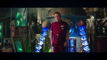 Movie still from “Ghostbusters” (2016), directed by Paul Feig – A man standing in front of a building with blue lights; Medium shot, Low angle