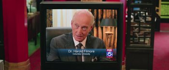 Movie still from “Ghostbusters” (2016), directed by Paul Feig – A television screen with a picture of dr; Close Up shot, High angle