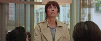 Movie still from “Ghostbusters” (2016), directed by Paul Feig – A person wearing a trench coat; Close Up shot, Over the shoulder angle