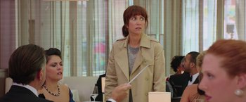 Movie still from “Ghostbusters” (2016), directed by Paul Feig – A woman in a trench coat is holding a white stick; Medium shot, Over the shoulder angle