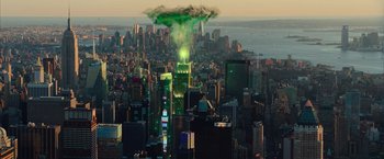 Movie still from “Ghostbusters” (2016), directed by Paul Feig – A green light is coming out of the top of the empire state building in new york city; Extreme Wide shot, Low angle