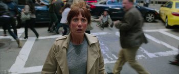 Movie still from “Ghostbusters” (2016), directed by Paul Feig – A person wearing a trench coat on a city street; Medium shot, High angle