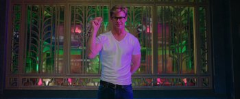 Movie still from “Ghostbusters” (2016), directed by Paul Feig – A man in a white t - shirt is pointing at the camera; Medium shot, Low angle