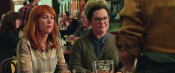 Movie still from “Ghostbusters” (2016), directed by Paul Feig – A woman sitting at a table in front of another woman; Close Up shot, Over the shoulder angle