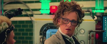 Movie still from “Ghostbusters” (2016), directed by Paul Feig – An older woman wearing glasses and a jacket; Close Up shot, Over the shoulder angle