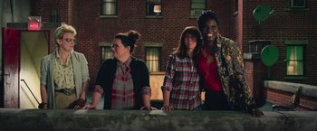 Movie still from “Ghostbusters” (2016), directed by Paul Feig – A group of women standing next to each other in front of a brick building; Medium shot, Over the shoulder angle