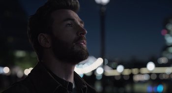 Movie still from “Ghosted” (2023), directed by Dexter Fletcher – A man with a beard is looking up at the sky; Close Up shot, Low angle