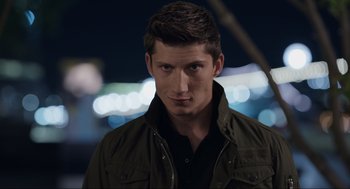 Movie still from “Ghosted” (2023), directed by Dexter Fletcher – A man in a green jacket is looking at the camera; Close Up shot, Low angle