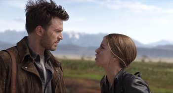 Movie still from “Ghosted” (2023), directed by Dexter Fletcher – A man and a woman face to face in an open field; Close Up shot, Low angle