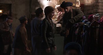 Movie still from “Ghosted” (2023), directed by Dexter Fletcher – A woman standing next to a man in a turban; Medium shot, Over the shoulder angle