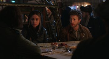 Movie still from “Ghosted” (2023), directed by Dexter Fletcher – A man and a woman sitting at a dinner table; Medium shot, Over the shoulder angle