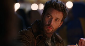 Movie still from “Ghosted” (2023), directed by Dexter Fletcher – A person wearing a leather jacket; Close Up shot, Low angle
