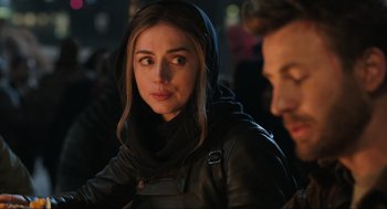 Movie still from “Ghosted” (2023), directed by Dexter Fletcher – A person wearing a jacket; Close Up shot, Over the shoulder angle
