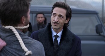 Movie still from “Ghosted” (2023), directed by Dexter Fletcher – A person wearing a suit and tie; Close Up shot, Over the shoulder angle