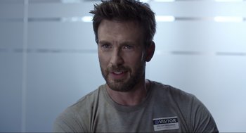 Movie still from “Ghosted” (2023), directed by Dexter Fletcher – A person wearing a t - shirt; Close Up shot, Over the shoulder angle