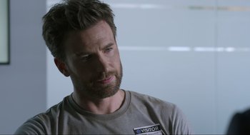 Movie still from “Ghosted” (2023), directed by Dexter Fletcher – A person with a beard; Close Up shot, Over the shoulder angle