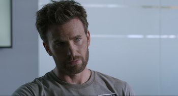 Movie still from “Ghosted” (2023), directed by Dexter Fletcher – A person with a beard looking at the camera; Close Up shot, Over the shoulder angle