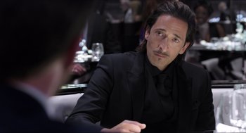 Movie still from “Ghosted” (2023), directed by Dexter Fletcher – A man in a black suit sitting in front of a woman; Close Up shot, Over the shoulder angle