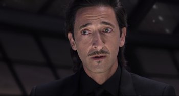 Movie still from “Ghosted” (2023), directed by Dexter Fletcher – A person wearing a suit and tie; Close Up shot, Low angle