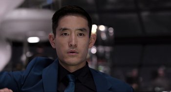 Movie still from “Ghosted” (2023), directed by Dexter Fletcher – A person wearing a suit and tie; Close Up shot, Over the shoulder angle