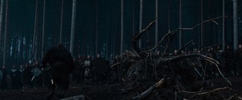 Movie still from “Gladiator” (2000), directed by Ridley Scott – A group of people standing in the middle of a forest; Wide shot, Low angle