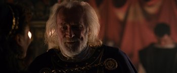 Movie still from “Gladiator” (2000), directed by Ridley Scott – An old man with white hair wearing a chain around his neck; Close Up shot, Over the shoulder angle