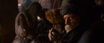 Movie still from “Gladiator” (2000), directed by Ridley Scott – An old man smoking a cigarette while holding a pipe; Close Up shot, Over the shoulder angle