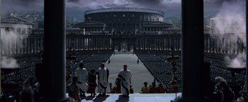 Movie still from “Gladiator” (2000), directed by Ridley Scott – A group of men in roman garb walking in front of an arena; Extreme Wide shot, High angle