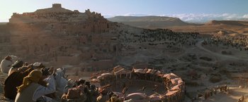 Movie still from “Gladiator” (2000), directed by Ridley Scott – A group of people standing around a circle in the middle of the desert; Extreme Wide shot, High angle