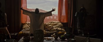 Movie still from “Gladiator” (2000), directed by Ridley Scott – A man standing in front of an open window with his arms outstretched; Wide shot, Low angle