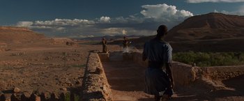 Movie still from “Gladiator” (2000), directed by Ridley Scott – A group of people standing on top of a dirt field; Extreme Wide shot, Over the shoulder angle