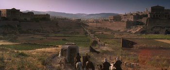 Movie still from “Gladiator” (2000), directed by Ridley Scott – A group of people riding on the back of a horse drawn carriage; Extreme Wide shot, High angle