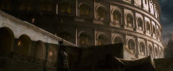 Movie still from “Gladiator” (2000), directed by Ridley Scott – A statue of a man in a suit stands in front of a building; Extreme Wide shot, Low angle
