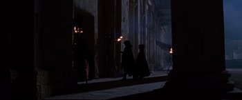 Movie still from “Gladiator” (2000), directed by Ridley Scott – A group of people dressed in black are standing in the dark with torches; Extreme Wide shot, Low angle
