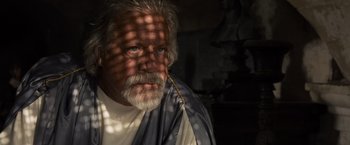 Movie still from “Gladiator” (2000), directed by Ridley Scott – A man with a long beard and a white shirt; Close Up shot, Low angle