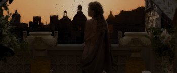 Movie still from “Gladiator” (2000), directed by Ridley Scott – A woman standing in front of a window at sunset; Medium shot, Low angle